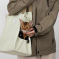 Load image into Gallery viewer, Close-up of the lightweight Oatmilk white cat travel tote worn over the shoulder.