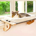 Load image into Gallery viewer, A fluffy cat lounging in a modern solid wood cat window perch with a plush white bed, attached to a bright window sill.
