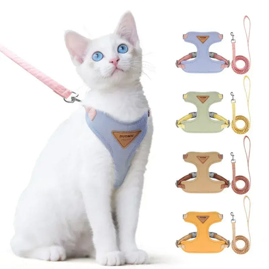 White indoor cat wearing a blue lightweight harness, with graphics highlighting the comfortable, ergonomic fit.