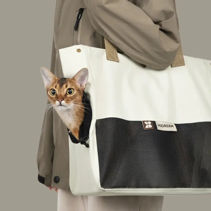 Owner wearing the modern color-block cat travel bag in Oatmilk white on shoulder.