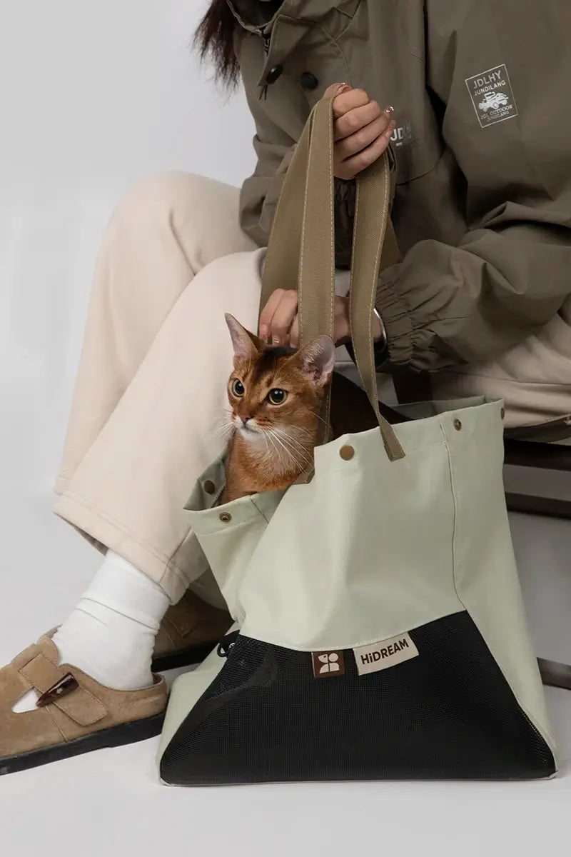 Owner sitting comfortably with the stylish Alpine Olive green cat carrier tote.