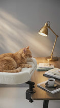 Load and play video in Gallery viewer, 360 Rotating Cat Desk Bed in plush white, side perspective view of the plush dual-sided cushion, washable cat bed pads. Cat leaning into it to sleep.
