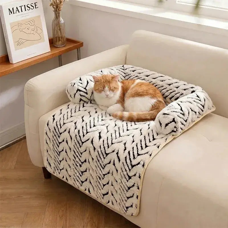 Orange and white cat curled up in The Sumi Lounger raised bolster cat bed on an armchair
