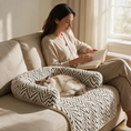 Load image into Gallery viewer, Woman reading on a sofa beside a cat napping on The Sumi Lounger zebra print pet bed
