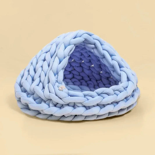 Chunky Knit Cocoon Cat Cave in ultra-thick hand-woven yarn, angled lower side view of the soft intertwined knit shapes.