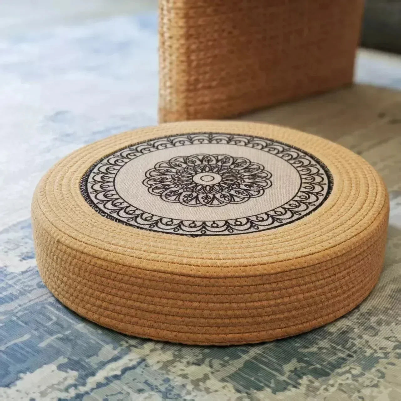 Tatami Zen Pouf in woven straw, low-angle front view of the intricate mandala design.
